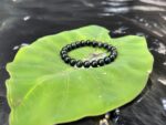 Overall view of Black Cat's Eye bracelet, deep luster with moving light band, embodies Water element energy.