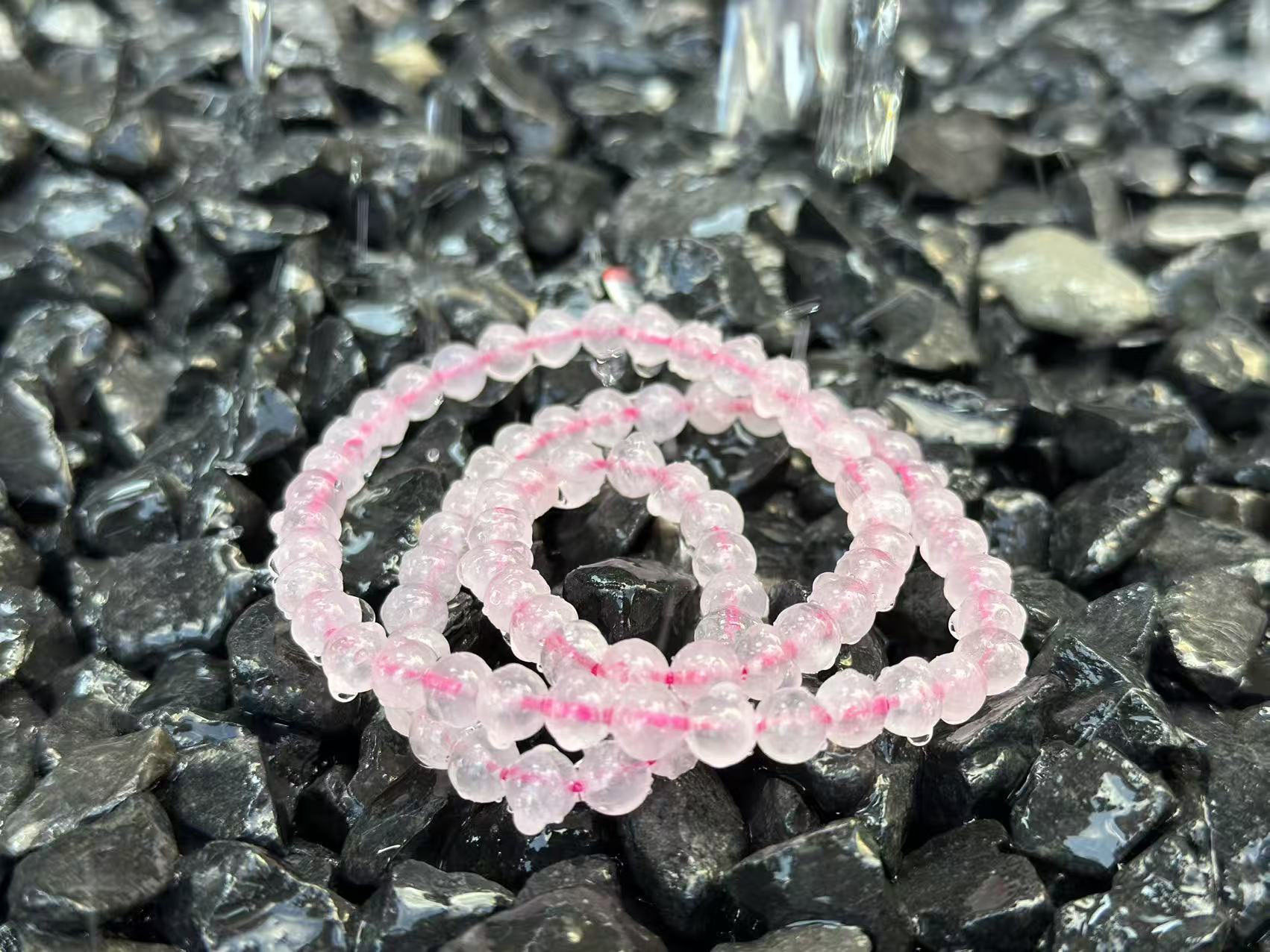 Rose Quartz necklace flat lay, soft pink blending Fire and Earth energy for love and stability.